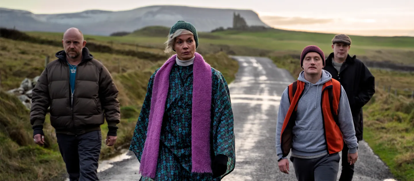 HORSESHOE main image  - four main characters walking down the road