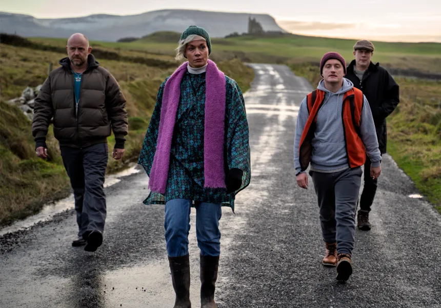 HORSESHOE main image  - four main characters walking down the road