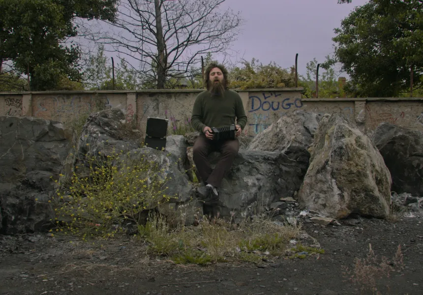 CELTIC UTOPIA main image, man sitting on rock 