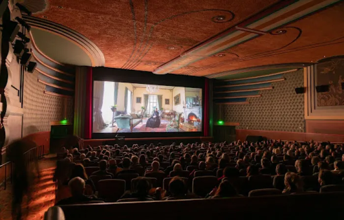 Theater full of people facing away, looking at screen