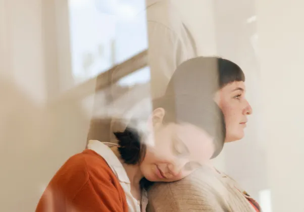 a woman's profile overlayed with other silhoeuttes and the glare from a window